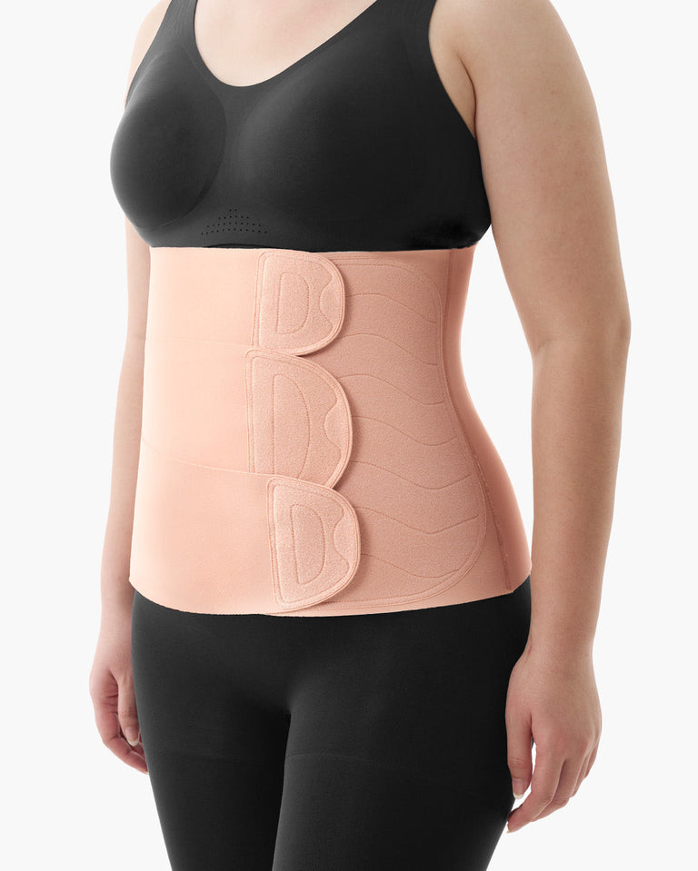 Translation missing: en.Momcozy Ergowrap Postpartum Belly Band in oyster pink color worn by a woman, with adjustable straps for postpartum support